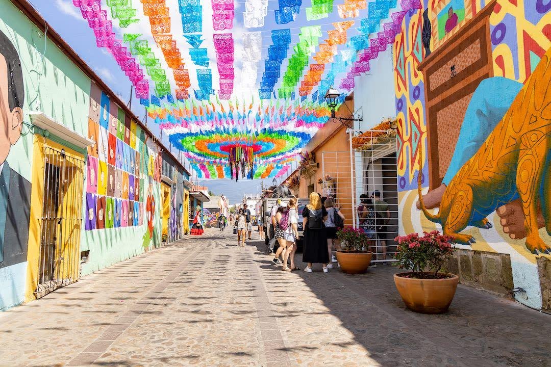 A colorful street draped in papel picado in a Mexican town