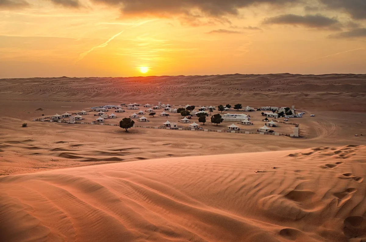 A desert safari camp among the dunes near Dubai at sunset